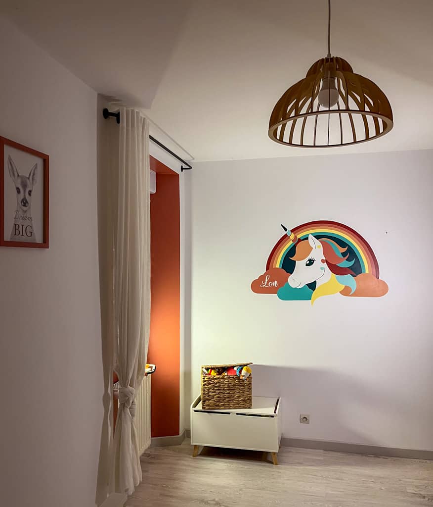 Cette fresque murale réalisée dans une chambre d'enfant représente une licorne colorée sous un arc-en-ciel, idéale pour créer un univers doux et poétique. Réalisée pour une chambre d’enfant aux tons terracotta, cette fresque licorne apporte une touche décorative unique et personnalisée.