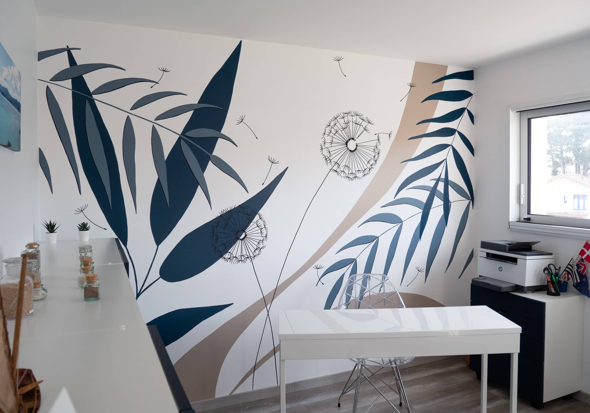 Fresque murale décorant un bureau avec des motifs végétaux, bleu marine et beige, pissenlit et feuilles tropicales
