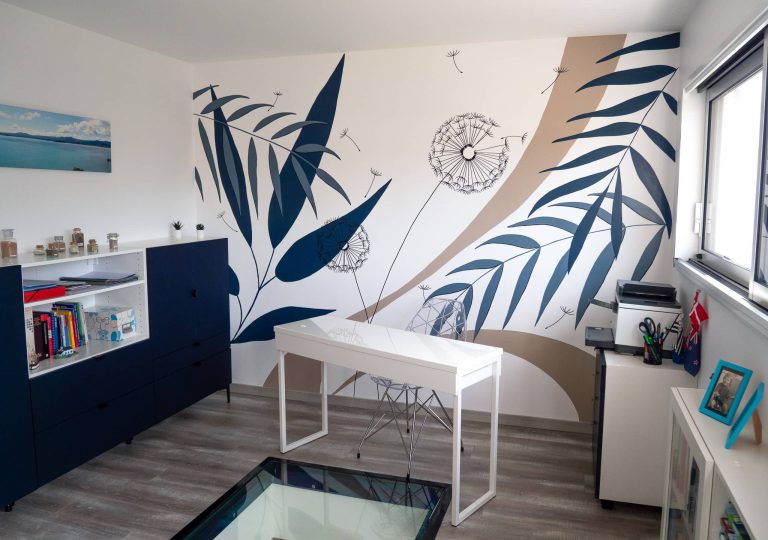 Fresque murale décorant un bureau avec des motifs végétaux, bleu marine et beige, pissenlit et feuilles tropicales