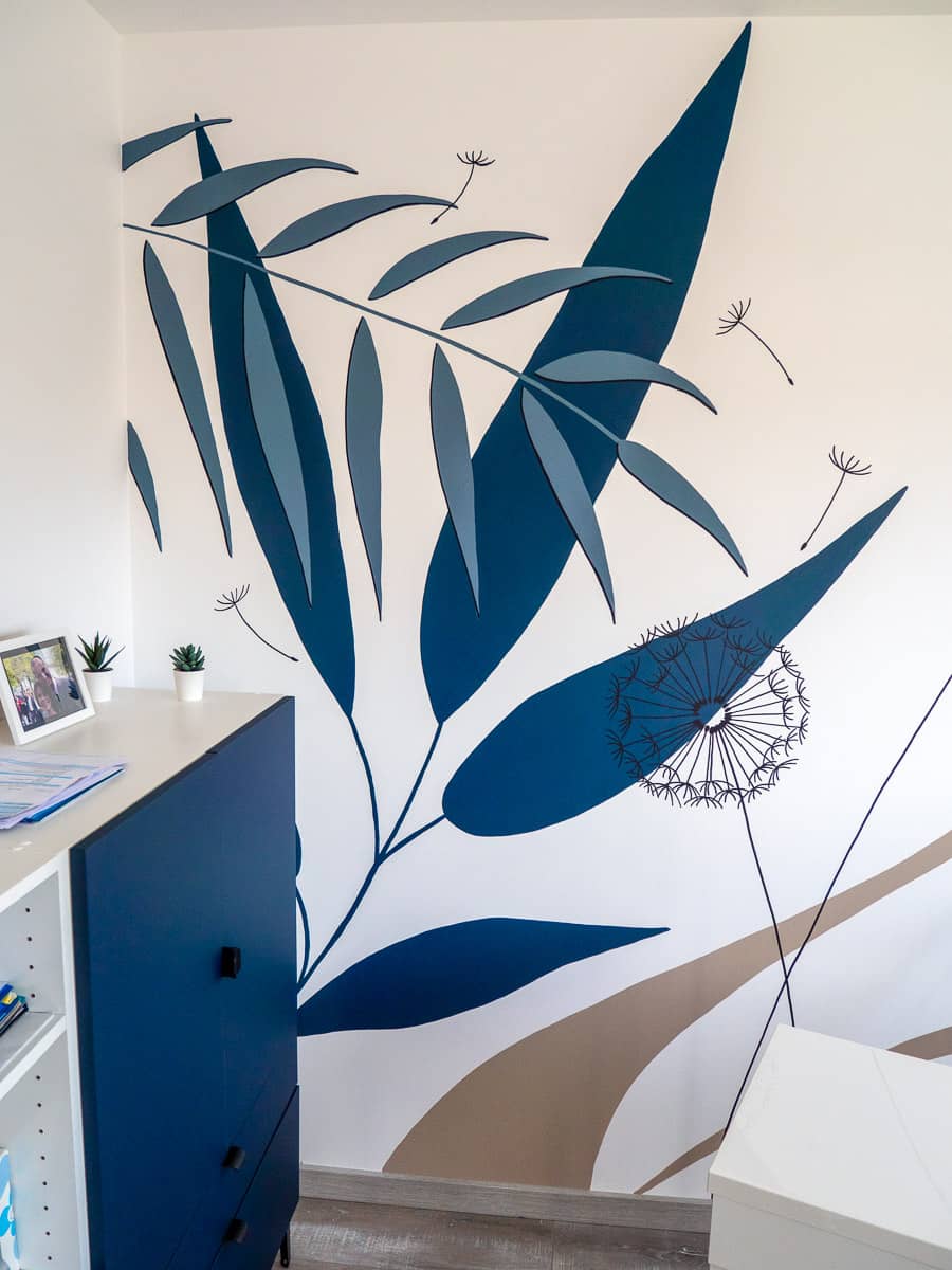 Zoom sur les feuillages ornant la fresque murale décorant un bureau.