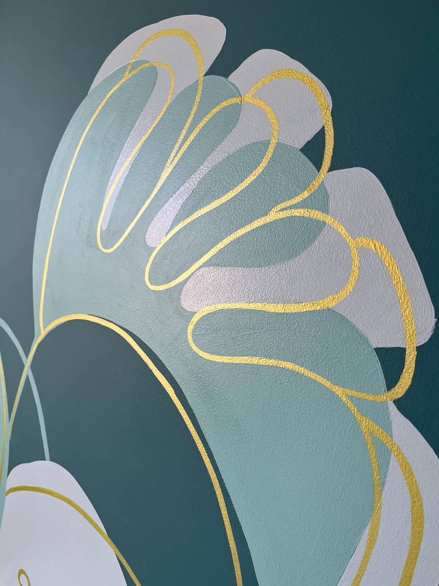 Fresque murale chambre adolescente peinte sur mesure. Gros plan sur une feuille de monstera, sur fond vert canard, rehaussés de touches dorées.